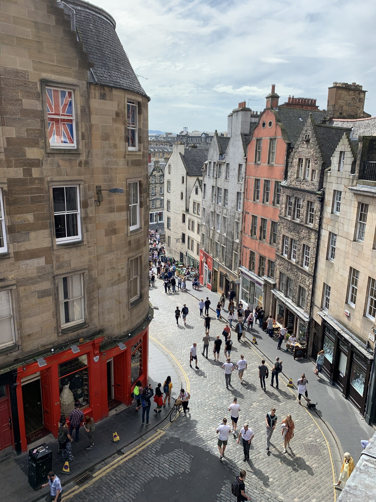 A crowded old city street viewed from high above between weathered stone buildings